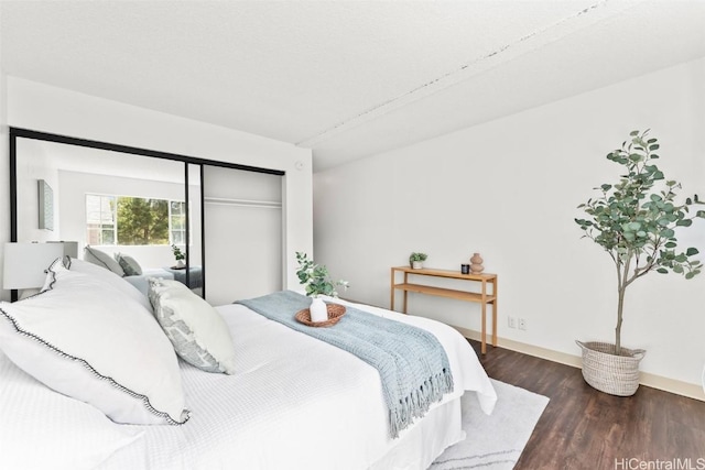 bedroom with a closet, baseboards, and wood finished floors