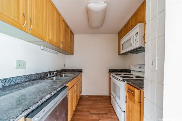 kitchen featuring white appliances, dark hardwood / wood-style flooring, and sink