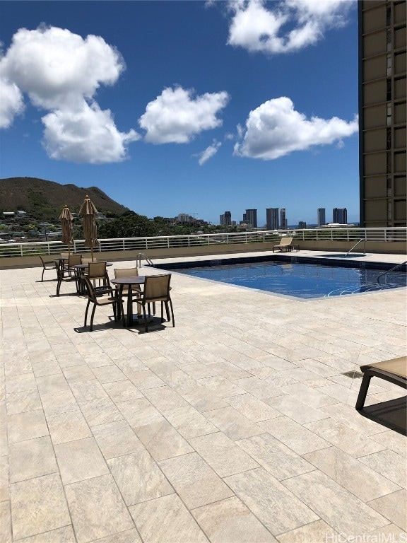 view of pool featuring a mountain view and a patio area