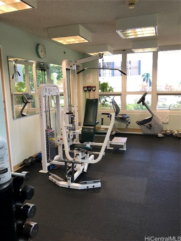 workout area with a textured ceiling and plenty of natural light