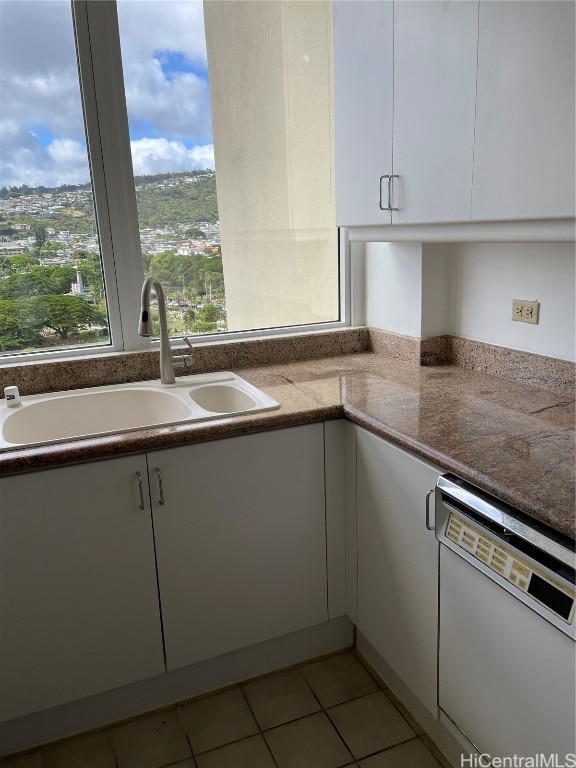 kitchen with white dishwasher, sink, and white cabinets