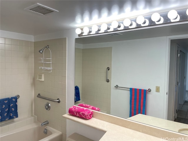 bathroom with vanity and tiled shower / bath combo