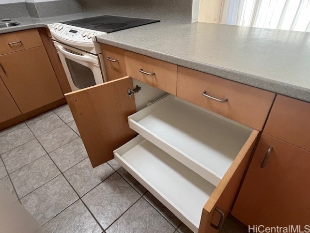 kitchen with sink, white range with electric cooktop, and light tile patterned floors