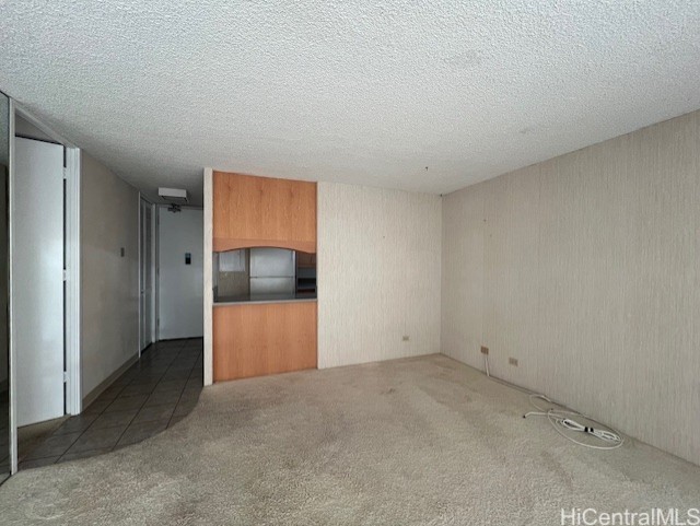 carpeted spare room featuring a textured ceiling