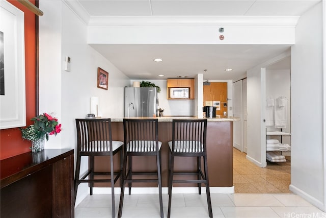 bar featuring crown molding, light tile patterned flooring, and stainless steel fridge