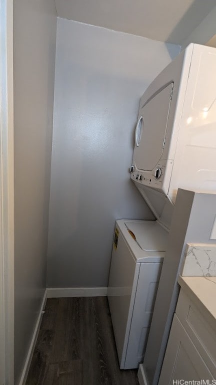 clothes washing area with stacked washer / dryer and dark hardwood / wood-style floors