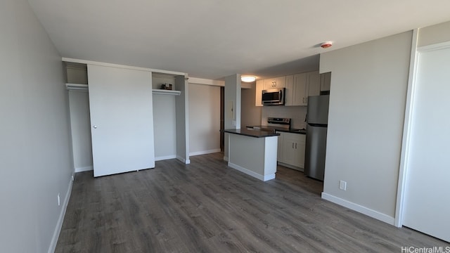 kitchen with appliances with stainless steel finishes, tasteful backsplash, and dark wood-type flooring