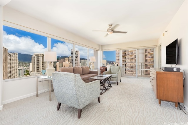 carpeted living room with ceiling fan