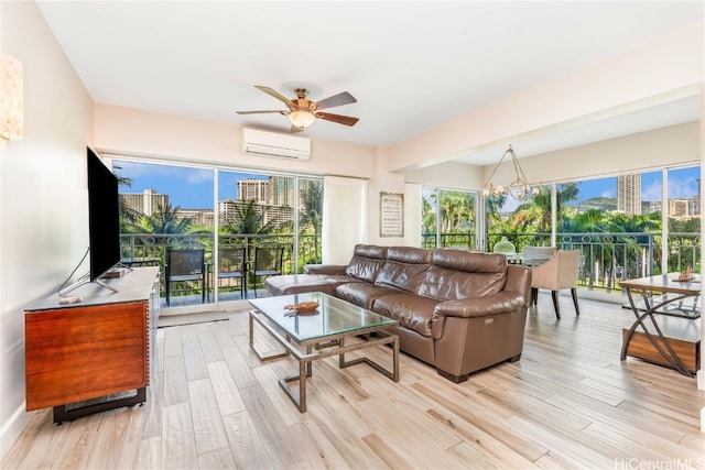 living room with light hardwood / wood-style flooring, a wall mounted air conditioner, and ceiling fan with notable chandelier