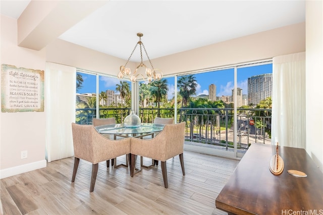 dining space featuring light hardwood / wood-style flooring and an inviting chandelier