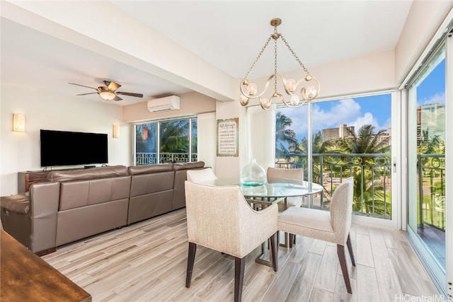 dining space featuring light hardwood / wood-style floors, a wall mounted AC, and ceiling fan with notable chandelier