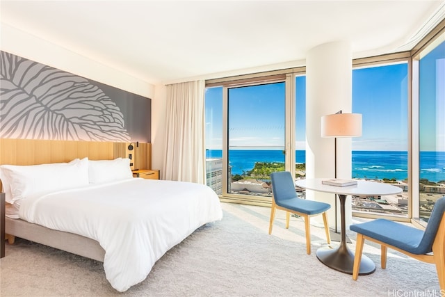 carpeted bedroom featuring a wall of windows and a water view