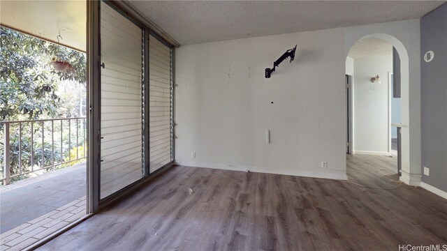 unfurnished room with light hardwood / wood-style floors and a textured ceiling