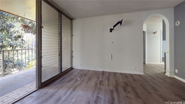 spare room with a textured ceiling and light hardwood / wood-style flooring