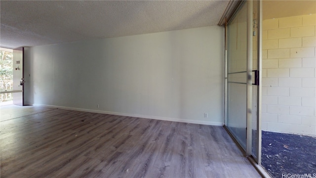 spare room featuring a textured ceiling and hardwood / wood-style flooring