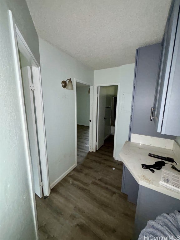 hallway with dark wood-type flooring and a textured ceiling