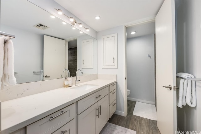 bathroom featuring vanity, hardwood / wood-style floors, and toilet