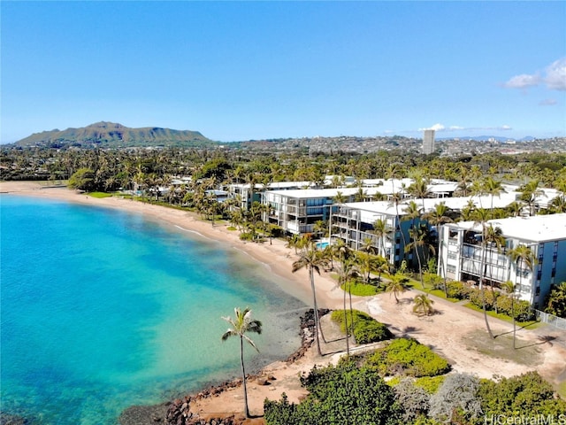 drone / aerial view with a water and mountain view and a view of the beach