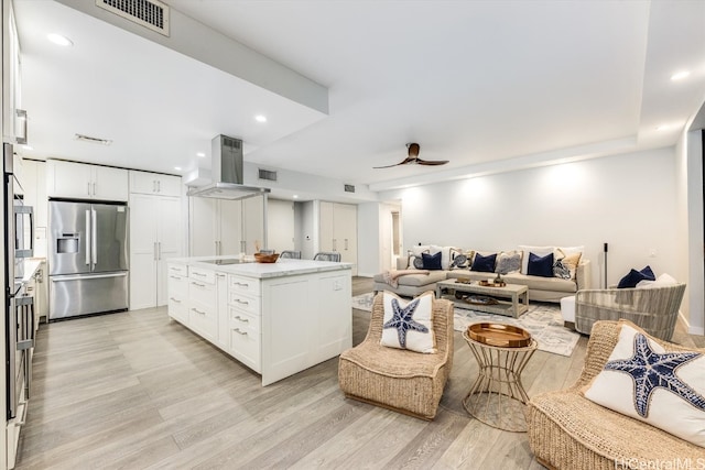 kitchen featuring a kitchen island, stainless steel fridge with ice dispenser, light wood-type flooring, white cabinets, and ceiling fan