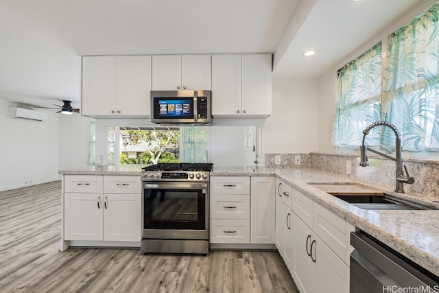 kitchen featuring light stone counters, white cabinetry, and stainless steel appliances