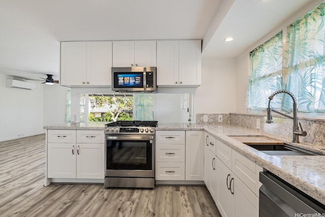 2340 University Ave, Honolulu, HI 96822 - kitchen featuring light wood-style flooring, a sink, recessed lighting, a wall mounted air conditioner, and appliances with stainless steel finishes