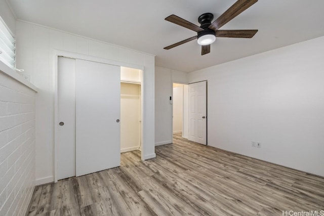 unfurnished bedroom with ceiling fan, a closet, and light hardwood / wood-style floors