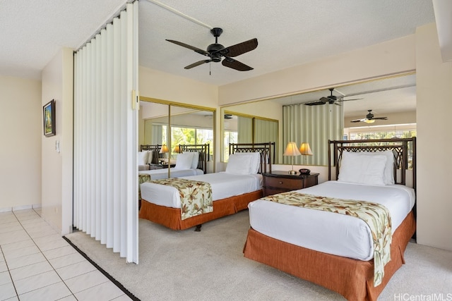 carpeted bedroom with a closet, ceiling fan, and a textured ceiling