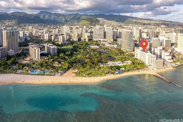 drone / aerial view featuring a water and mountain view and a beach view