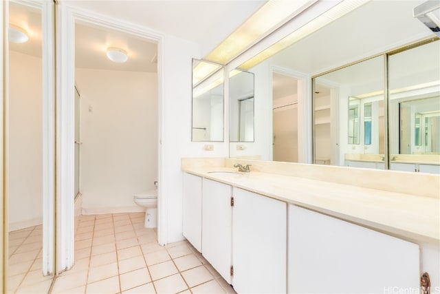 bathroom with vanity, toilet, and tile patterned floors