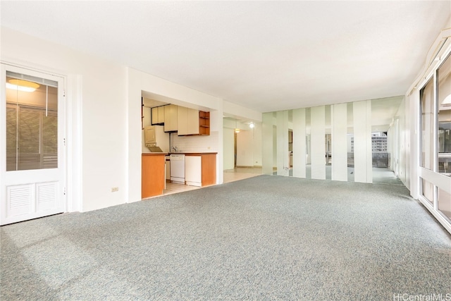 unfurnished living room with light carpet and sink