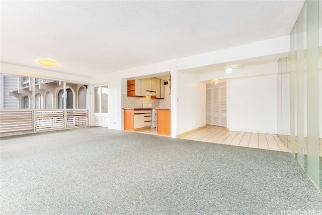 unfurnished living room with light carpet and a textured ceiling