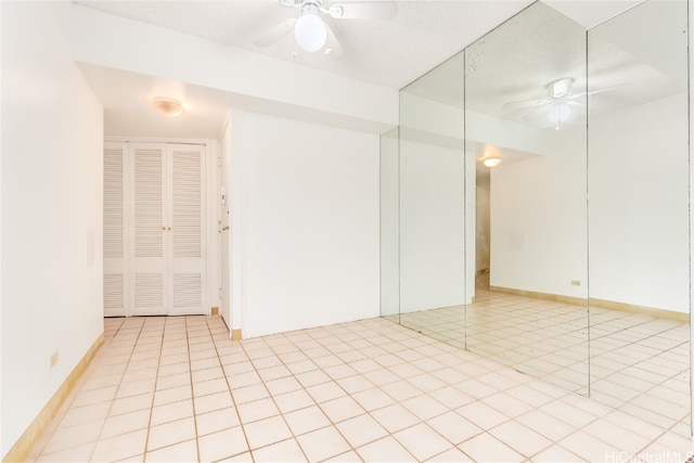 tiled spare room with ceiling fan