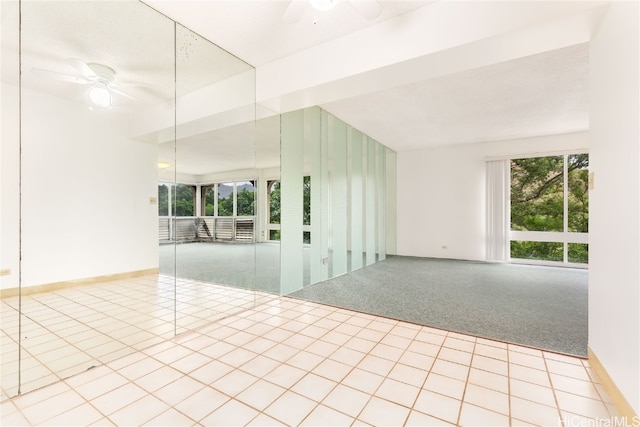 carpeted spare room featuring ceiling fan and plenty of natural light