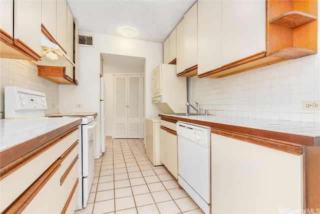 kitchen featuring decorative backsplash, white cabinets, light tile patterned floors, sink, and white appliances