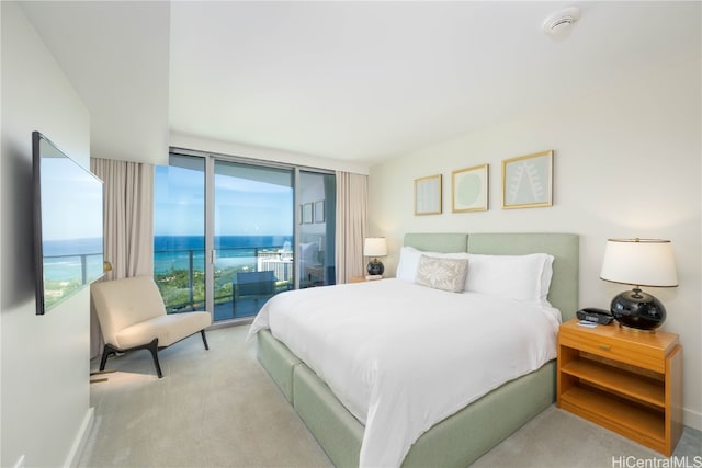 carpeted bedroom featuring a water view, floor to ceiling windows, and access to exterior