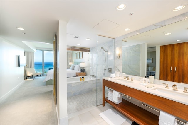 bathroom featuring vanity, independent shower and bath, and a water view