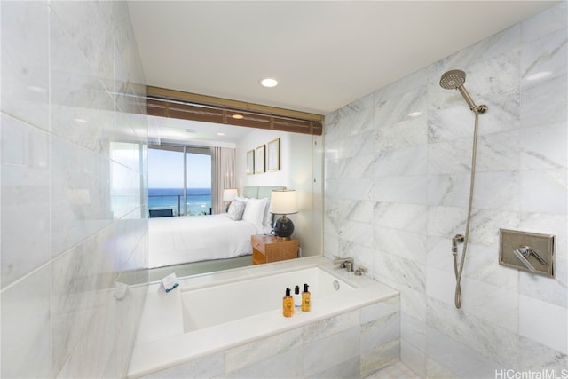 bathroom featuring tile walls, independent shower and bath, and a water view