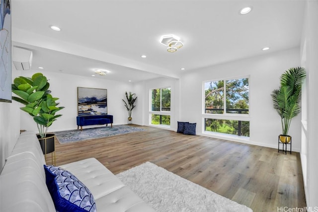 living room featuring hardwood / wood-style flooring and a wall mounted AC