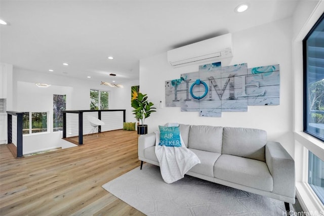 living room featuring wood-type flooring and an AC wall unit