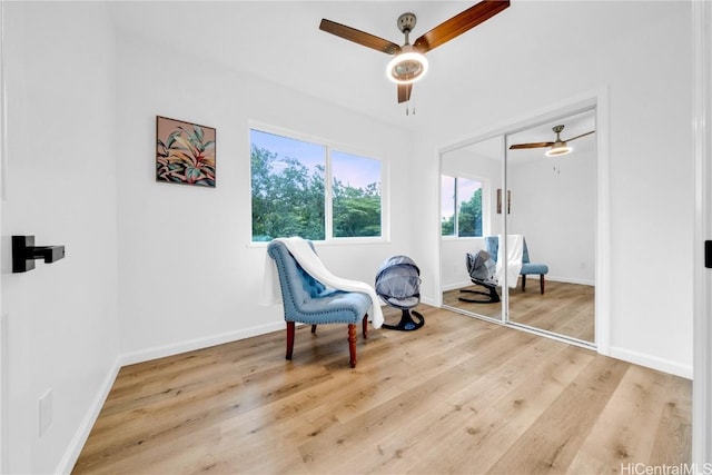 sitting room with ceiling fan and light wood-type flooring