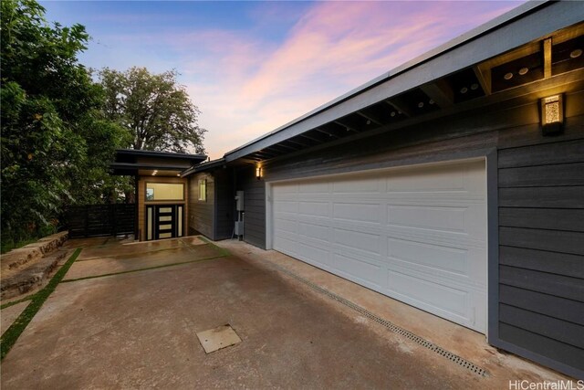 view of garage at dusk