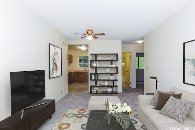 carpeted living room with ceiling fan