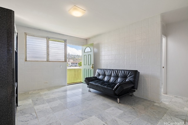 living area featuring tile walls