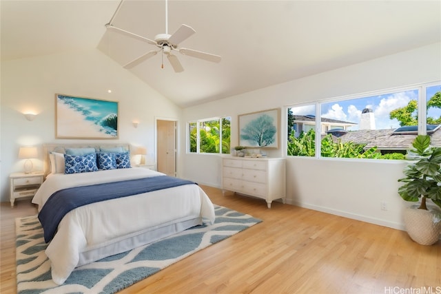 bedroom with ceiling fan, light hardwood / wood-style floors, and vaulted ceiling