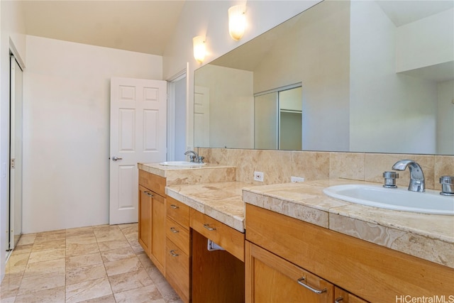 bathroom featuring backsplash, vanity, and lofted ceiling