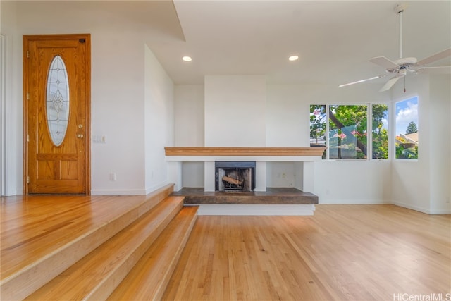 unfurnished living room featuring ceiling fan and hardwood / wood-style floors