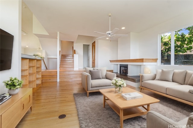 living room with light wood-type flooring and ceiling fan