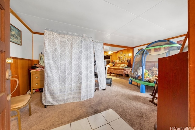 rec room featuring wood walls, carpet floors, and ornamental molding