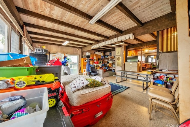 interior space with wood walls, beam ceiling, and a wealth of natural light