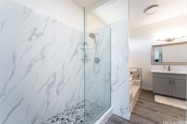 bathroom with vanity, a tile shower, and wood-type flooring